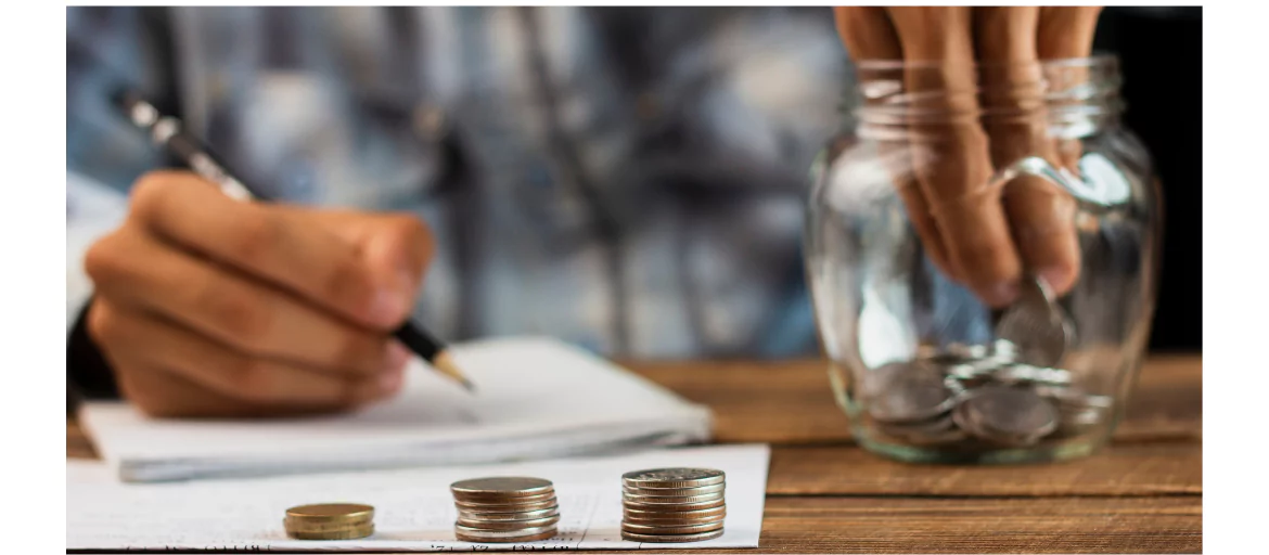 hand putting coins in a jar